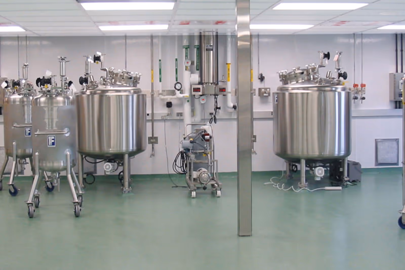Large stainless steel mixing tanks in a clean, industrial laboratory setting