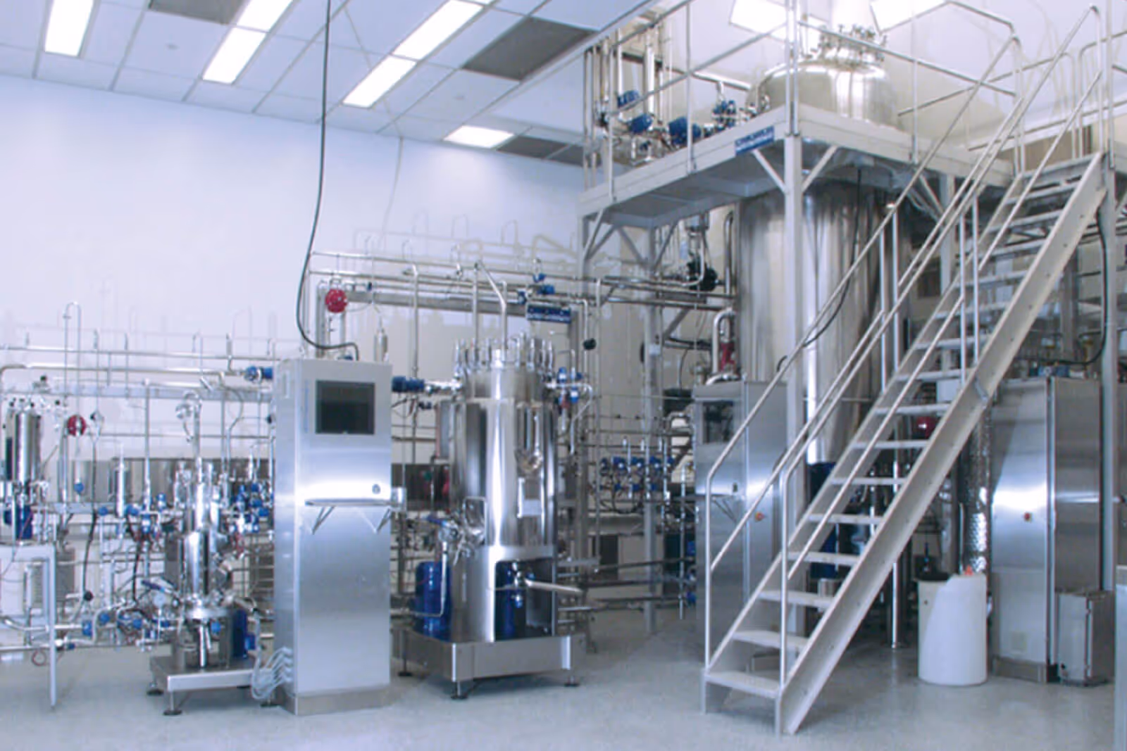 Modern industrial processing facility with large metallic equipment and stairs