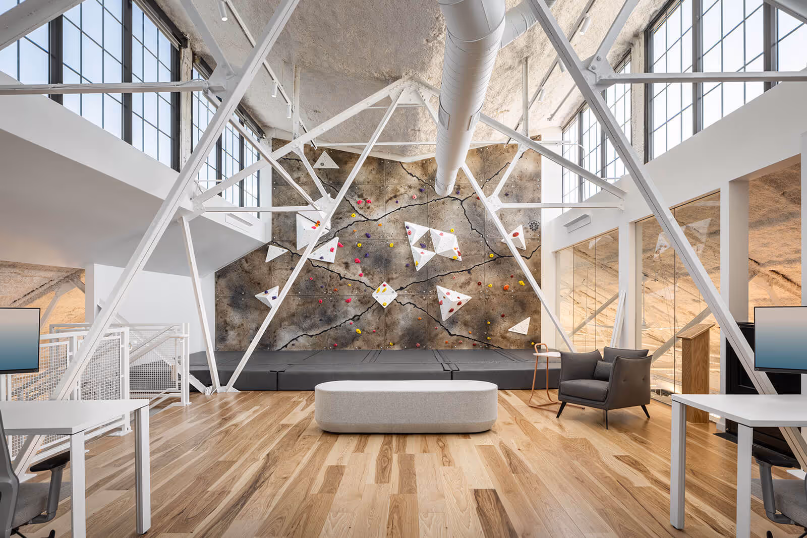 Modern office with geometric wall art, climbing wall, and minimalist furniture