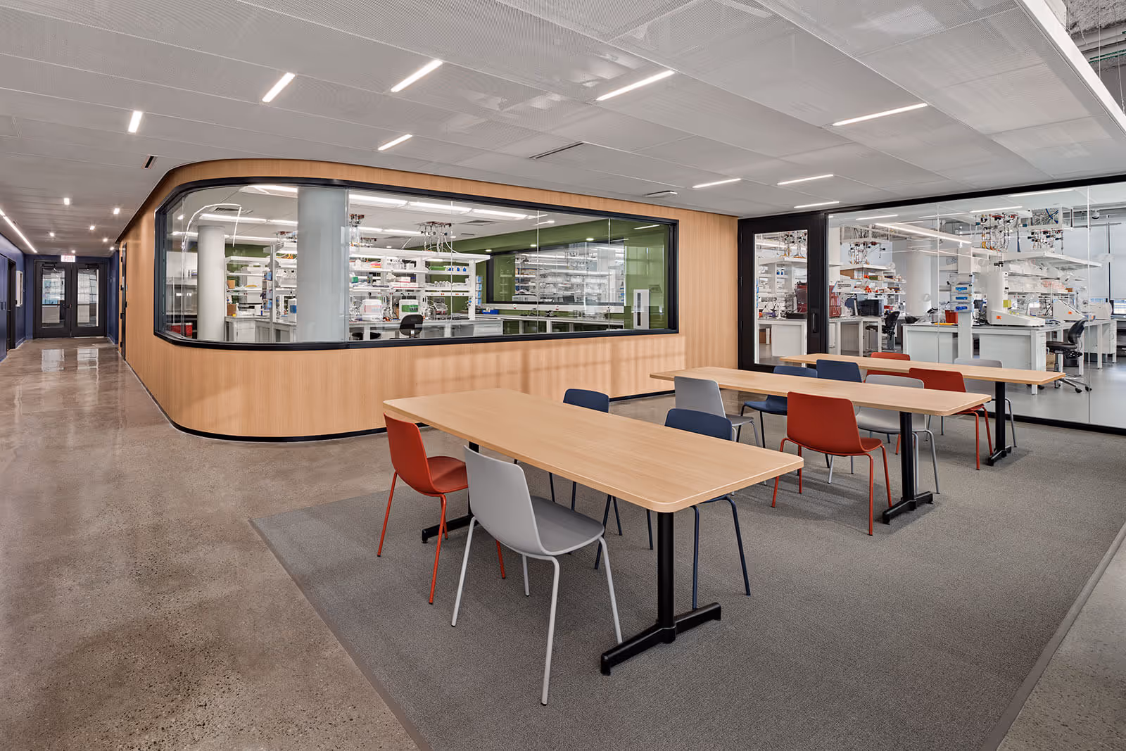 Modern laboratory meeting space with large windows overlooking research facilities