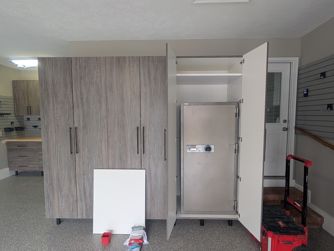 Gray car parked in a clean garage with white cabinets, drawers, and organized shelves along the back wall for optimal garage storage.