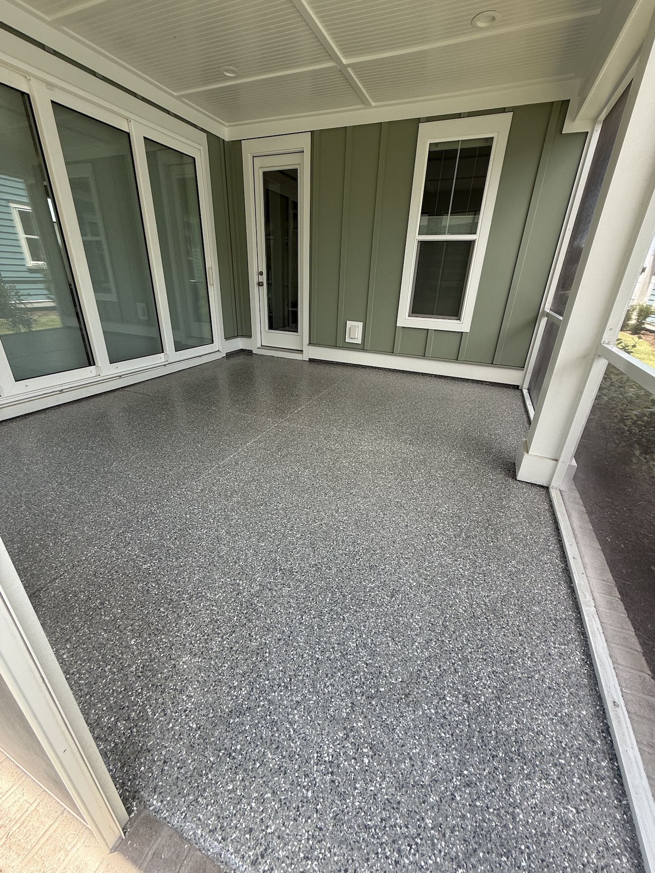 Gray car parked in a clean garage with white cabinets, drawers, and organized shelves along the back wall for optimal garage storage.