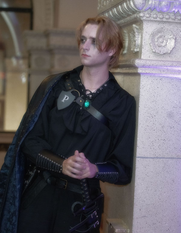 A god named Azareth from The Paravelle Fantasy Ball Vanguard of Valor in Los Angeles leaning up against a pillar at The Majestic Downtown
