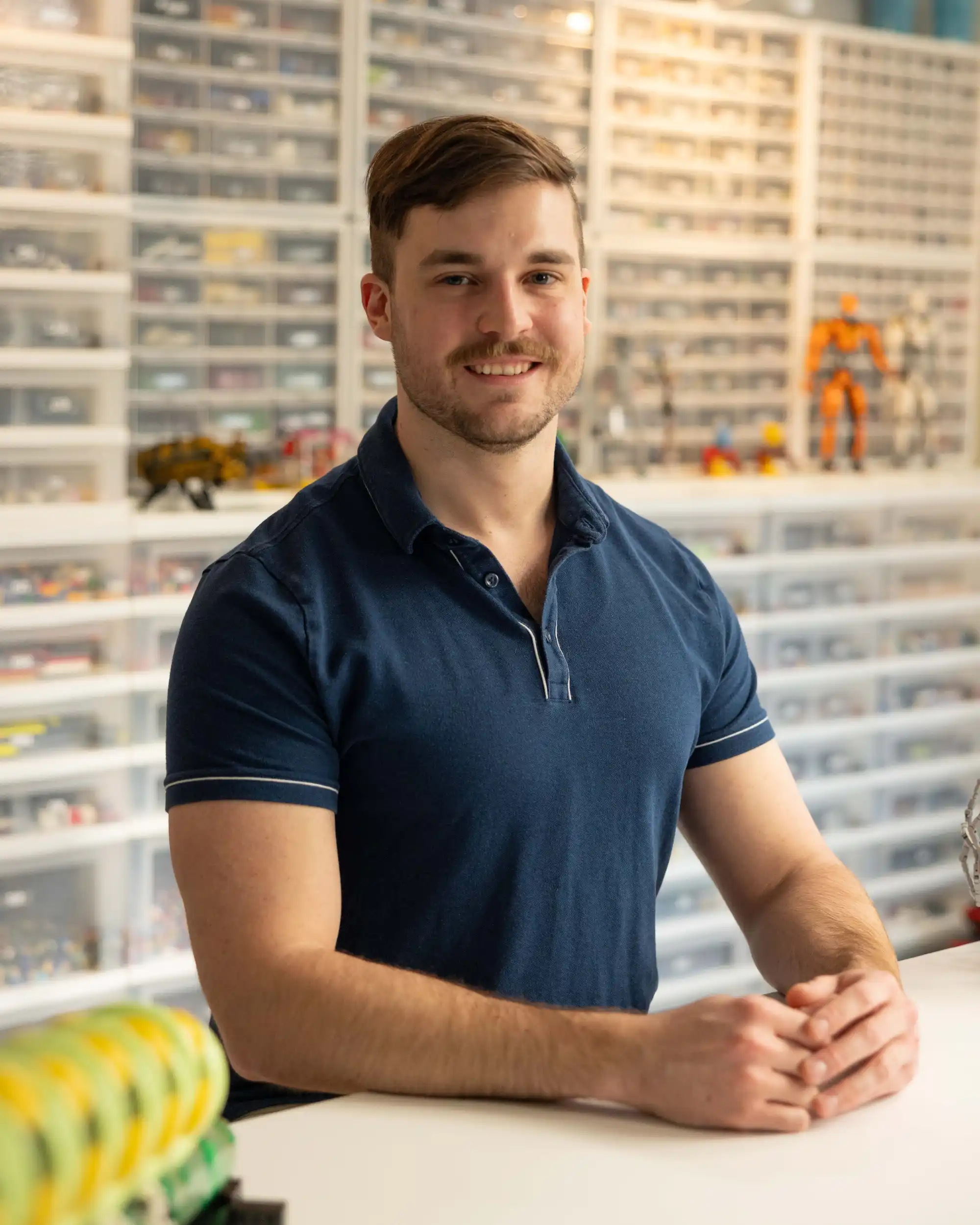 Ben posing in front of one of his LEGO storage walls in his studio.