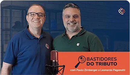 Banner promocional do programa 'Bastidores do Tributo' com Paulo Zirnberger e Leonardo Paganotti. Ambos estão em pé, sorrindo, em um estúdio de gravação com um microfone profissional em primeiro plano.