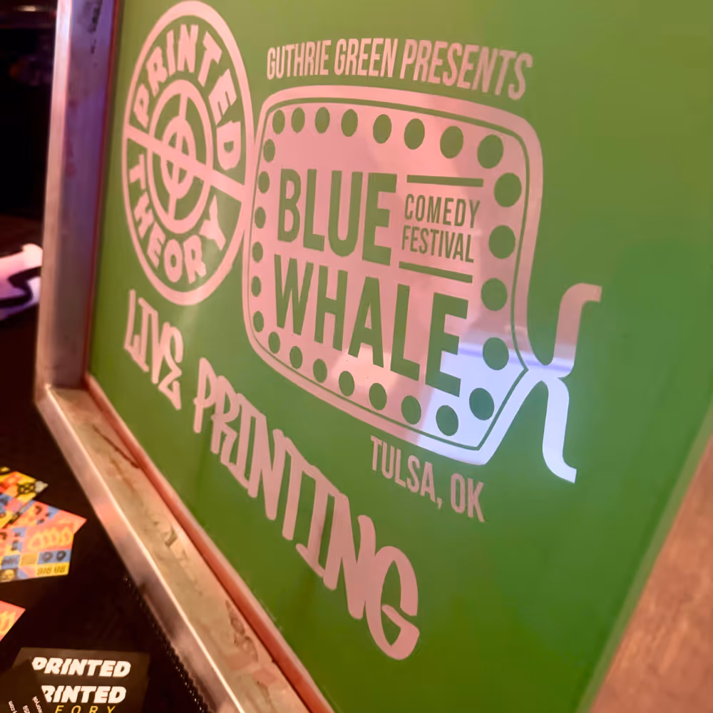 Close-up of a green screen with the Blue Whale Comedy Festival print setup, showcasing the live printing station during the event.