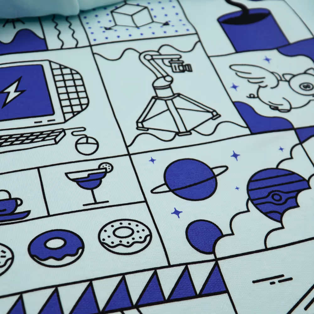 Close-up of Signal Factory hoodie print featuring creative, illustrative design with planets, donuts, and camera.