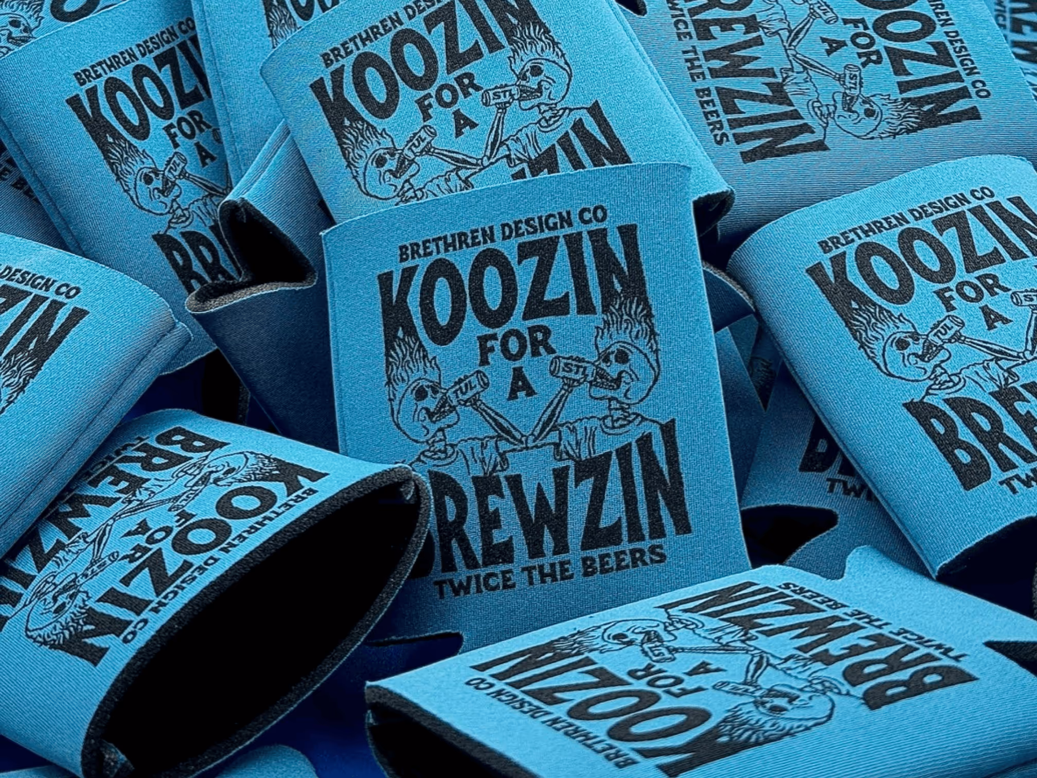 Pile of Brethren Design Co blue koozies with skeleton artwork and text "Koozin for a Brewzin."