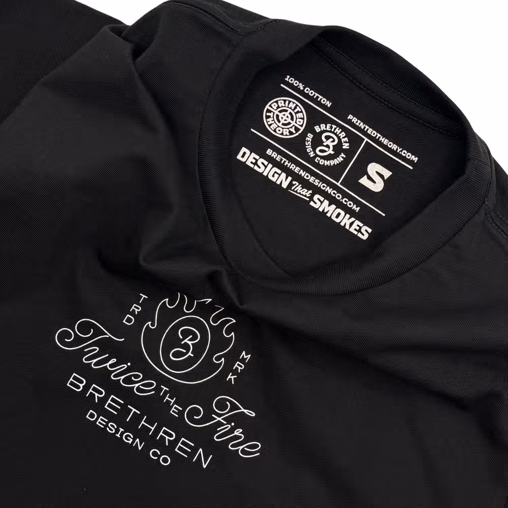 Flat lay of Brethren Design Co black t-shirt showing "Twice the Fire" logo and printed size label.