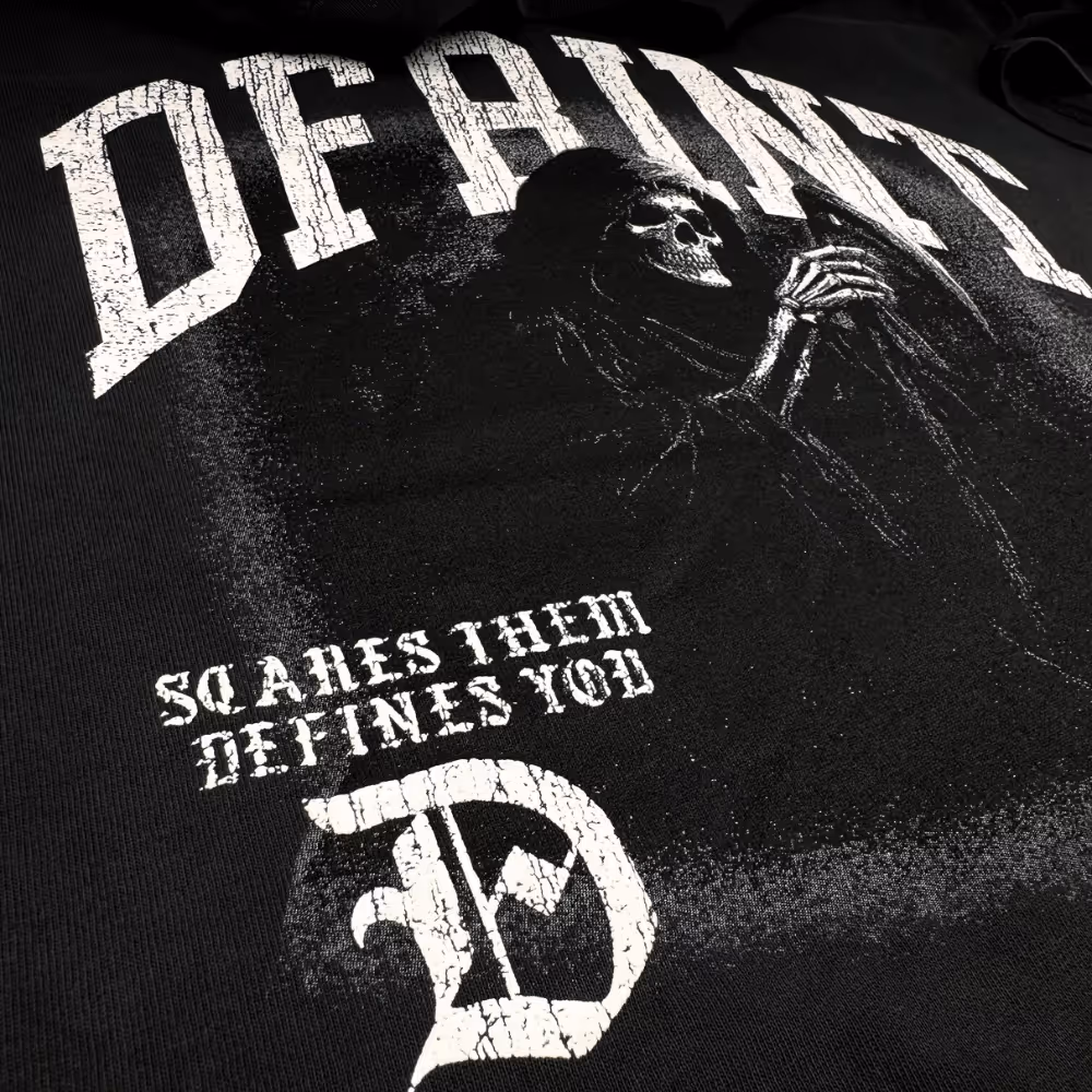 Close-up of DFRINT t-shirt featuring grim reaper illustration and 'Scares Them, Defines You' slogan in distressed print.