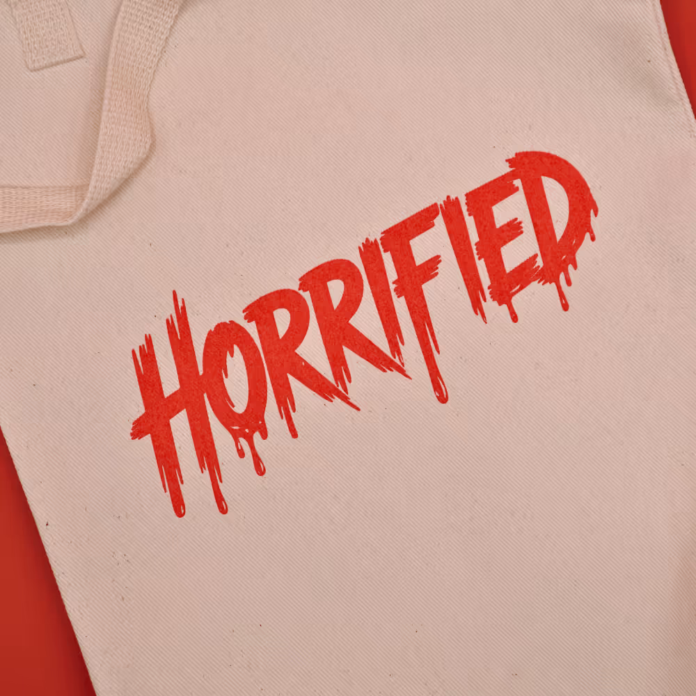 A canvas tote bag with the word horrified screen printed in red 