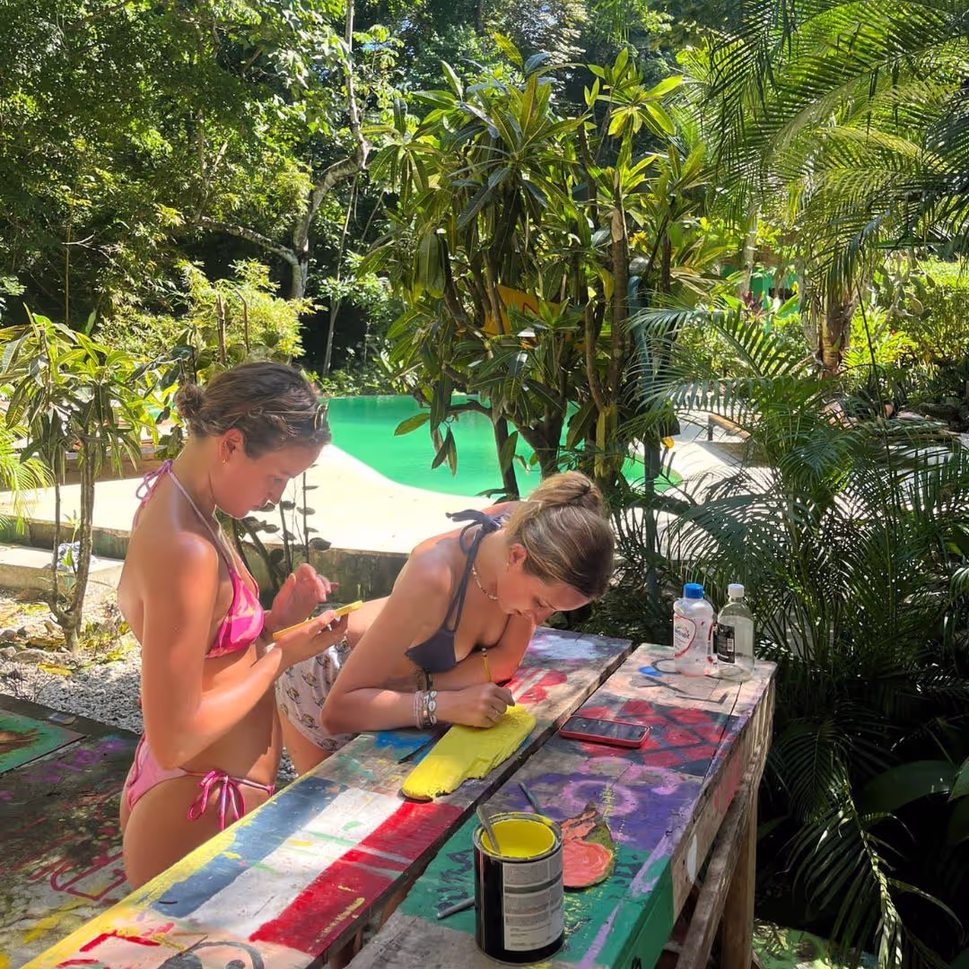 2 young people painting a sign on a Costa Rica gap year adventure from The Leap
