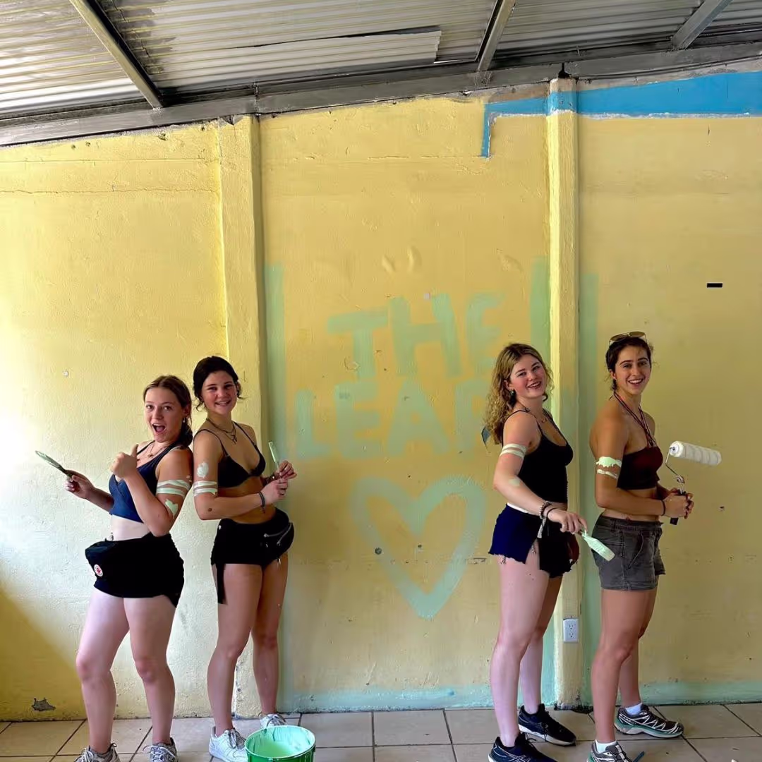Group of young people in their gap year adventure from the Leap painting a school building in Costa Rica