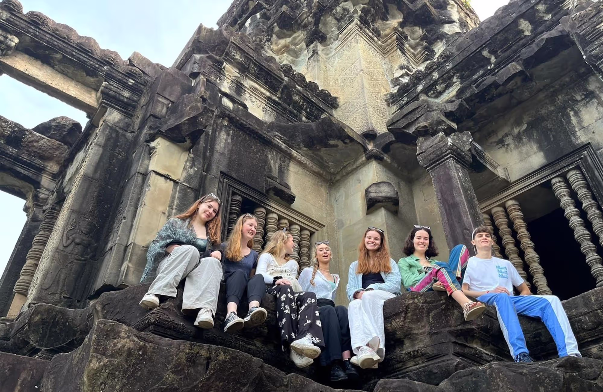 Group of gap year students sitting amongst the ruins of Siem Reap, Cambodia - The Leap Cambodia gap year programme