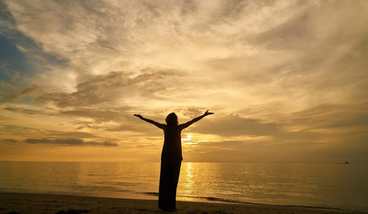 woman embracing the earth representing the wellbeing investment of a midlife Leap