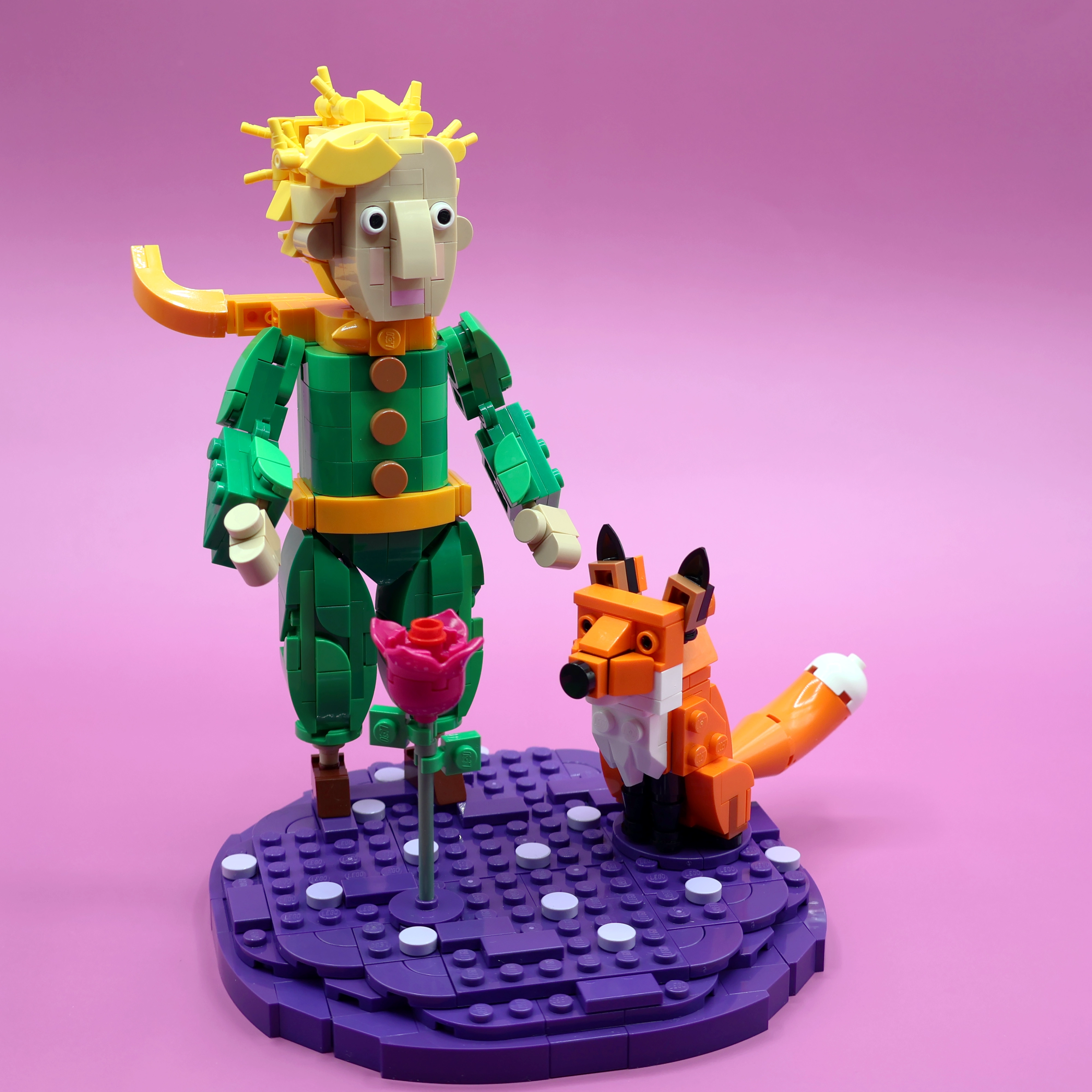 A custom LEGO commission by Ben Brickson of a the Little Prince, and his fox friend standing on the surface of a purple planet