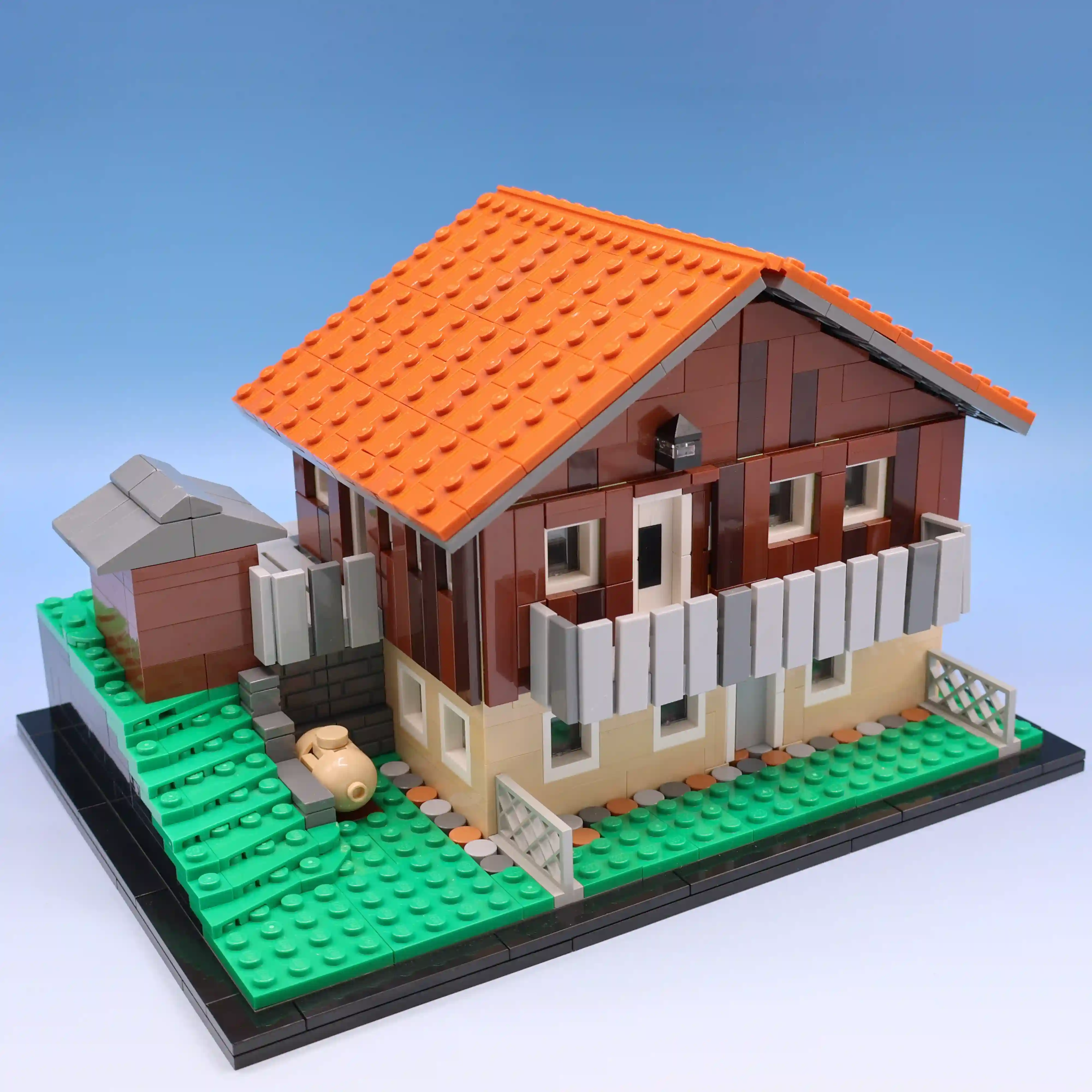 A commissioned build of someone's childhood home situated on a hill with an overlooking deck.