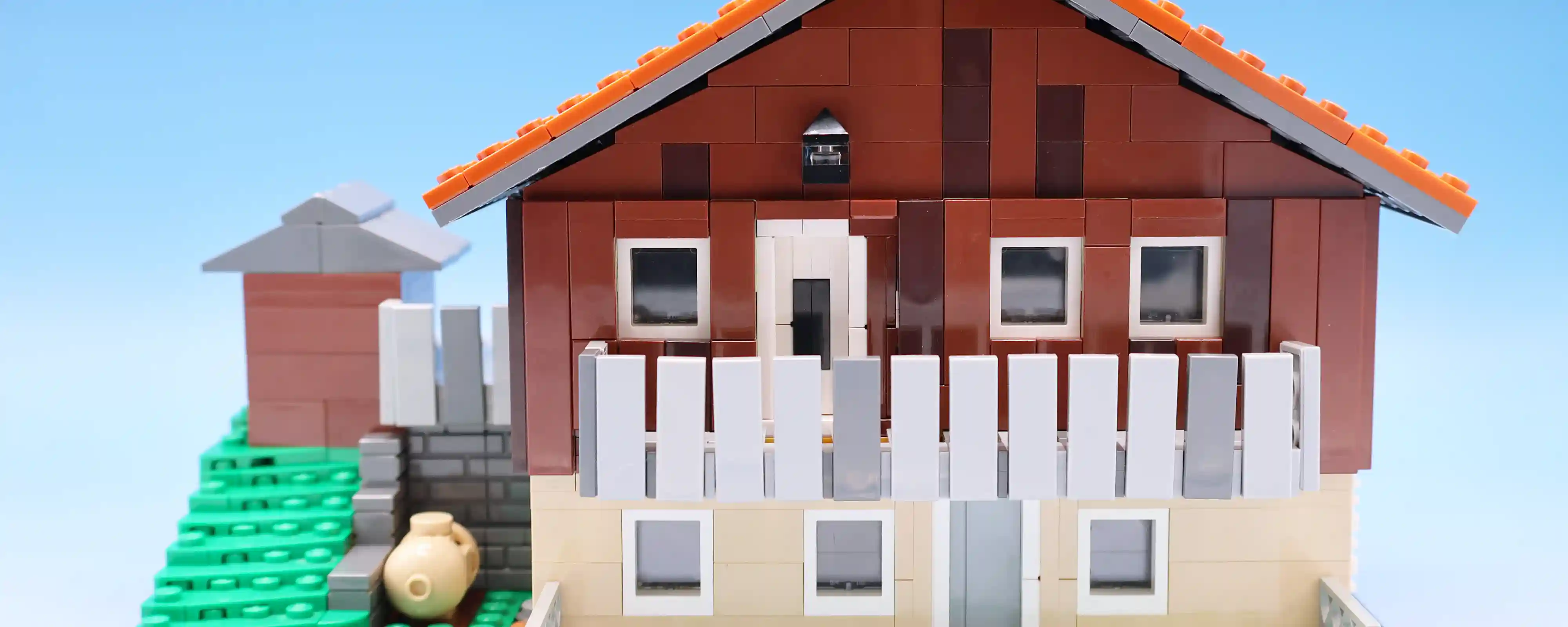 A commissioned build of someone's childhood home situated on a hill with an overlooking deck.