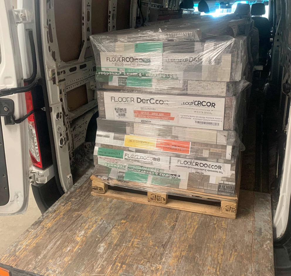 Pallet of vinyl floor tiles wrapped in plastic, loaded inside a white delivery van.