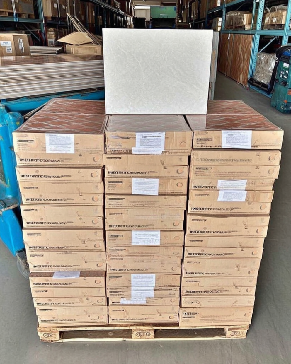 Pallet of beige ceramic floor tiles neatly stacked with a sample tile displayed on top.