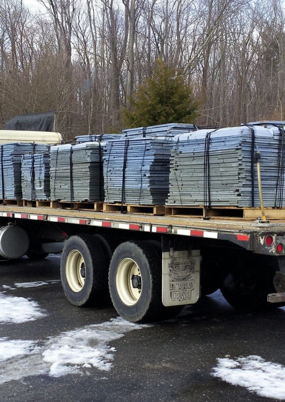 Bulk natural blue stone slabs loaded on flatbed truck for construction supply delivery.