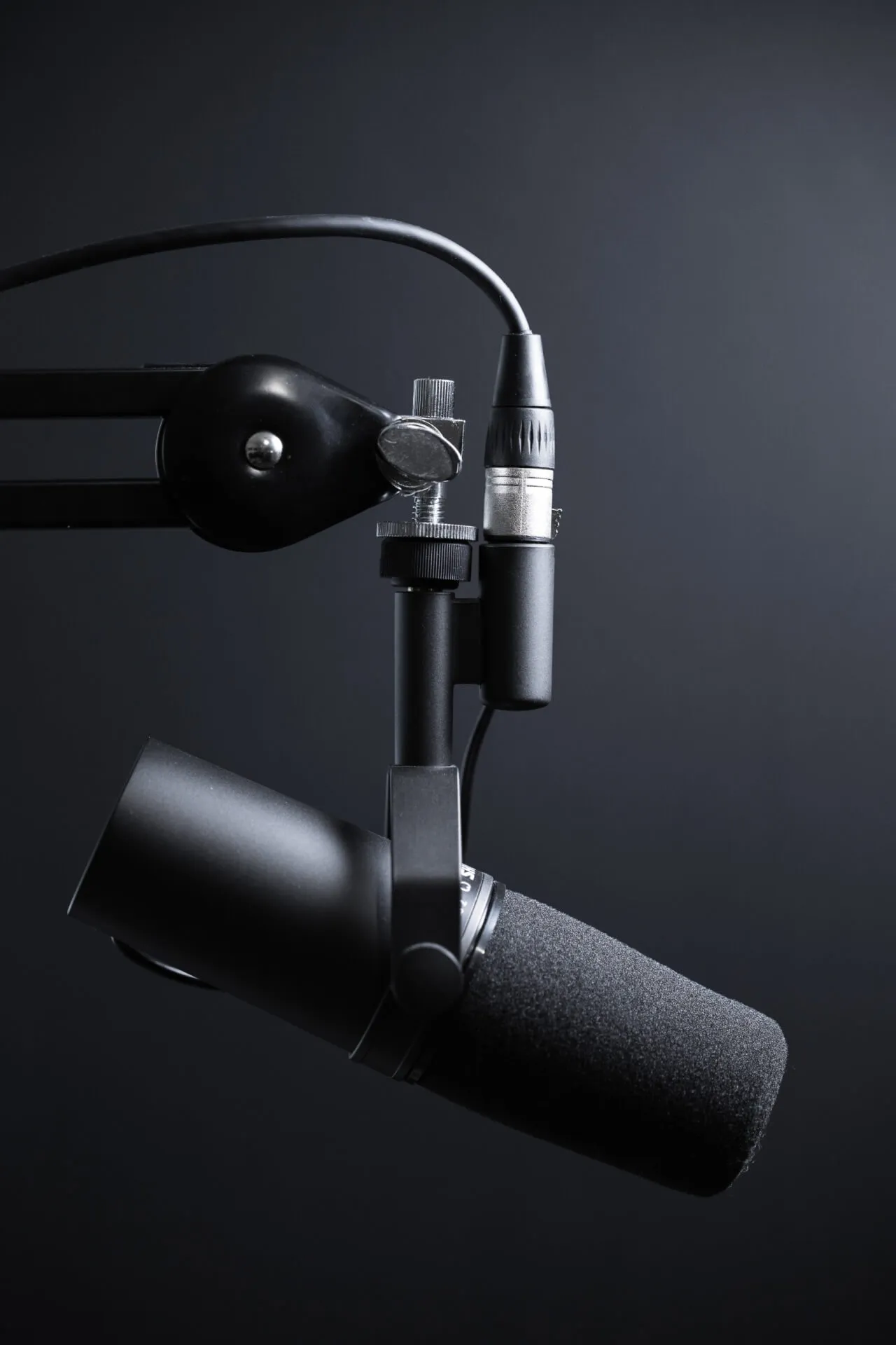 a microphone attached to a microphone stand on a black background