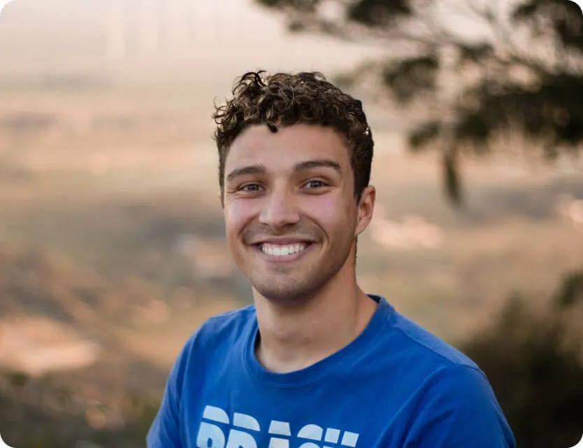 a man with curly hair wearing a blue shirt