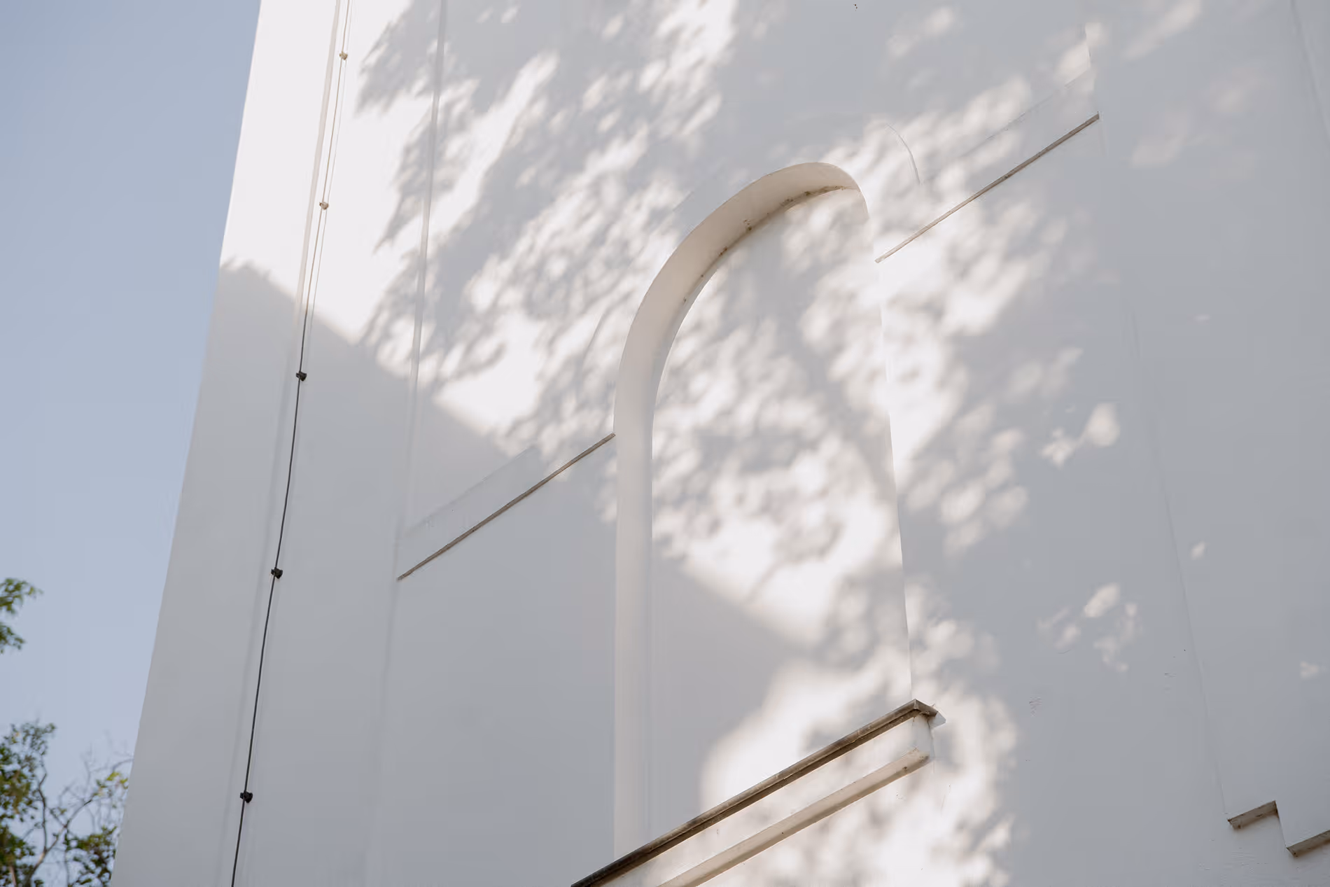Relyon weiße Hauswand mit Schatten der Bäume