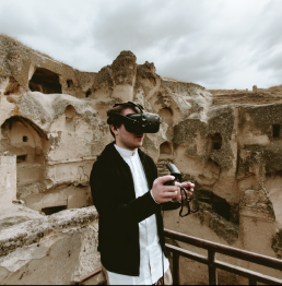 An image of a man using a VR headset. He is surrounded by ancient ruins