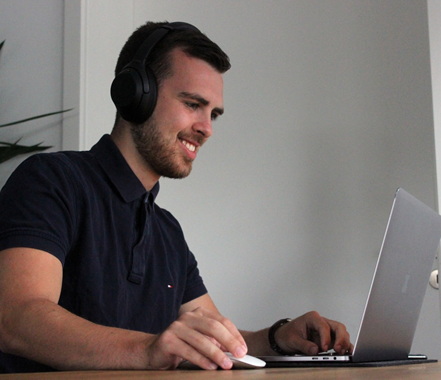 Junger Mann schaut und hört Online Kurs zu 