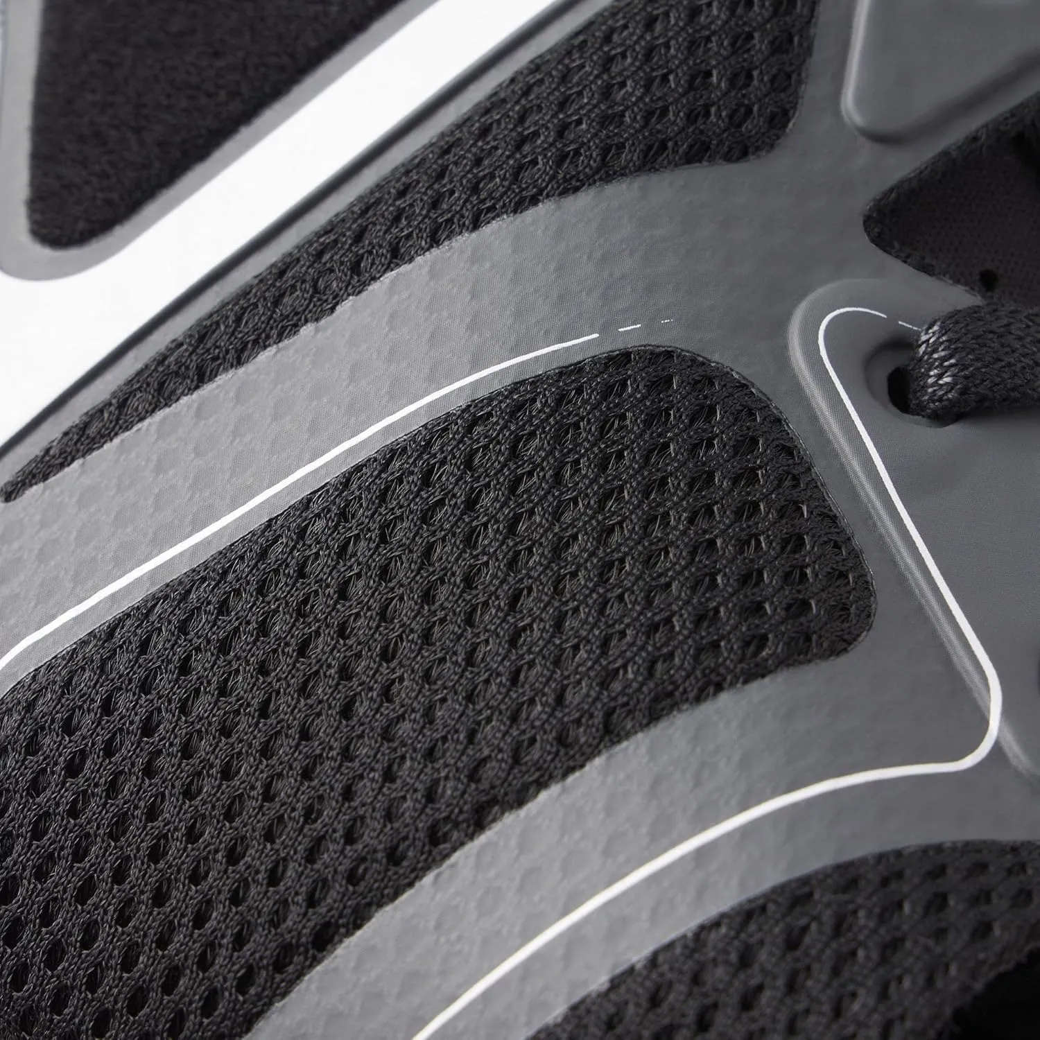 Close-up of black textured mesh and synthetic material on a sports shoe with a white outlined logo.
