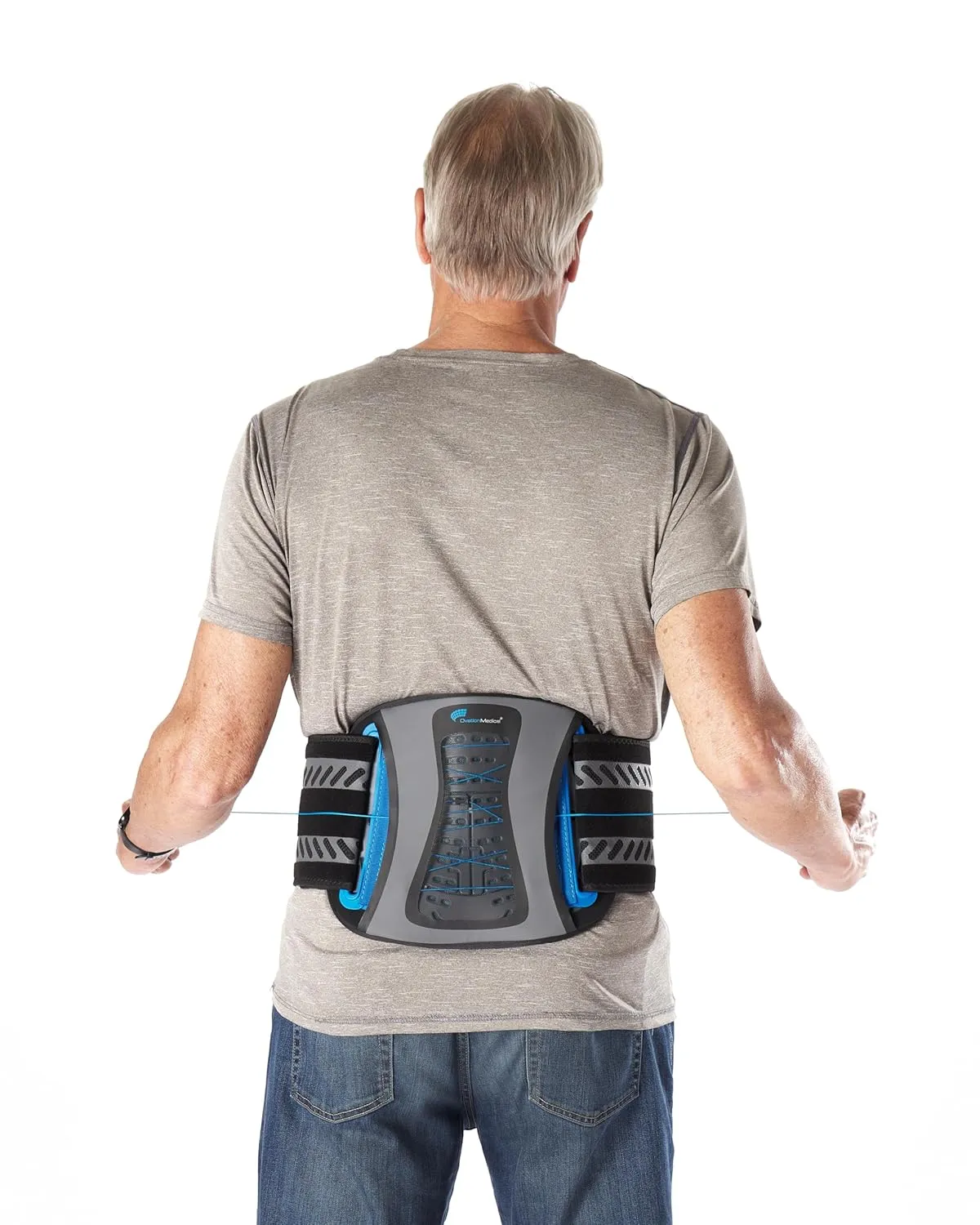 Older man seen from behind wearing a gray back brace with blue accents over a gray t-shirt and blue jeans.
