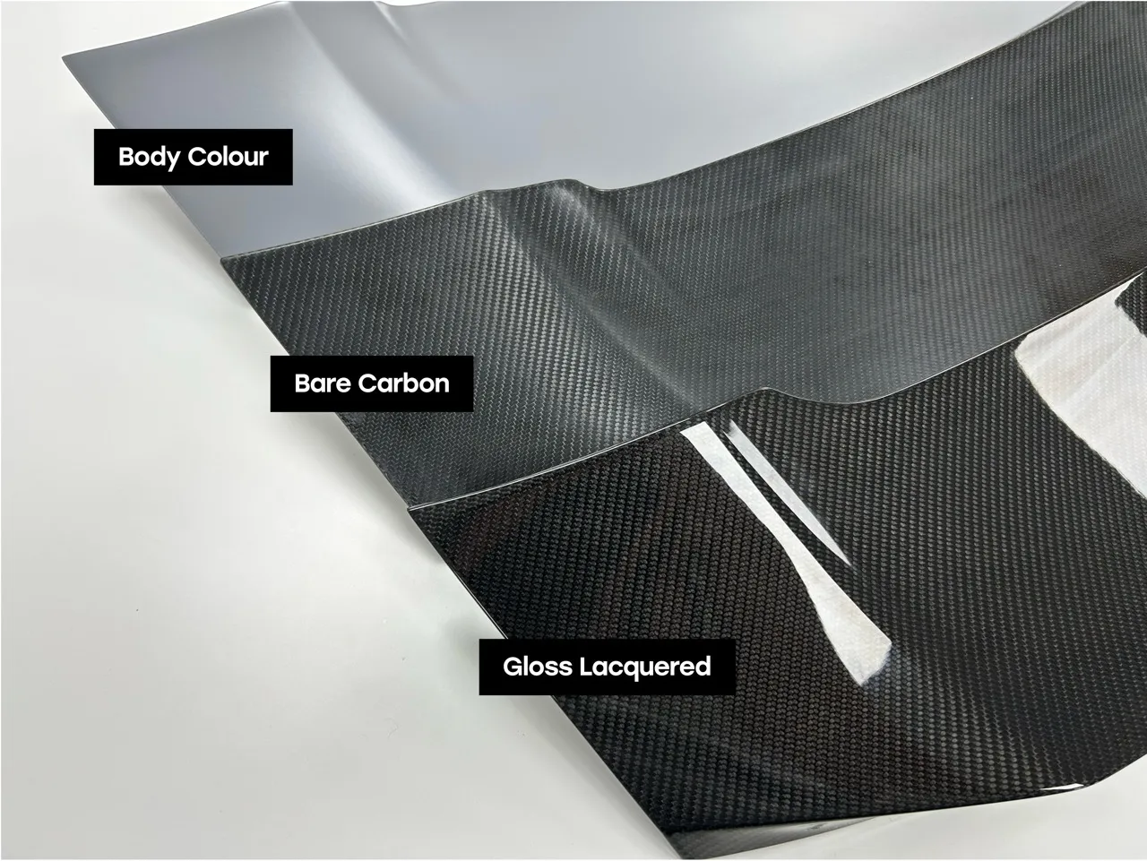 Comparison of three finishes on a carbon fiber panel: body colour paint, bare carbon fiber, and gloss lacquered carbon fiber.