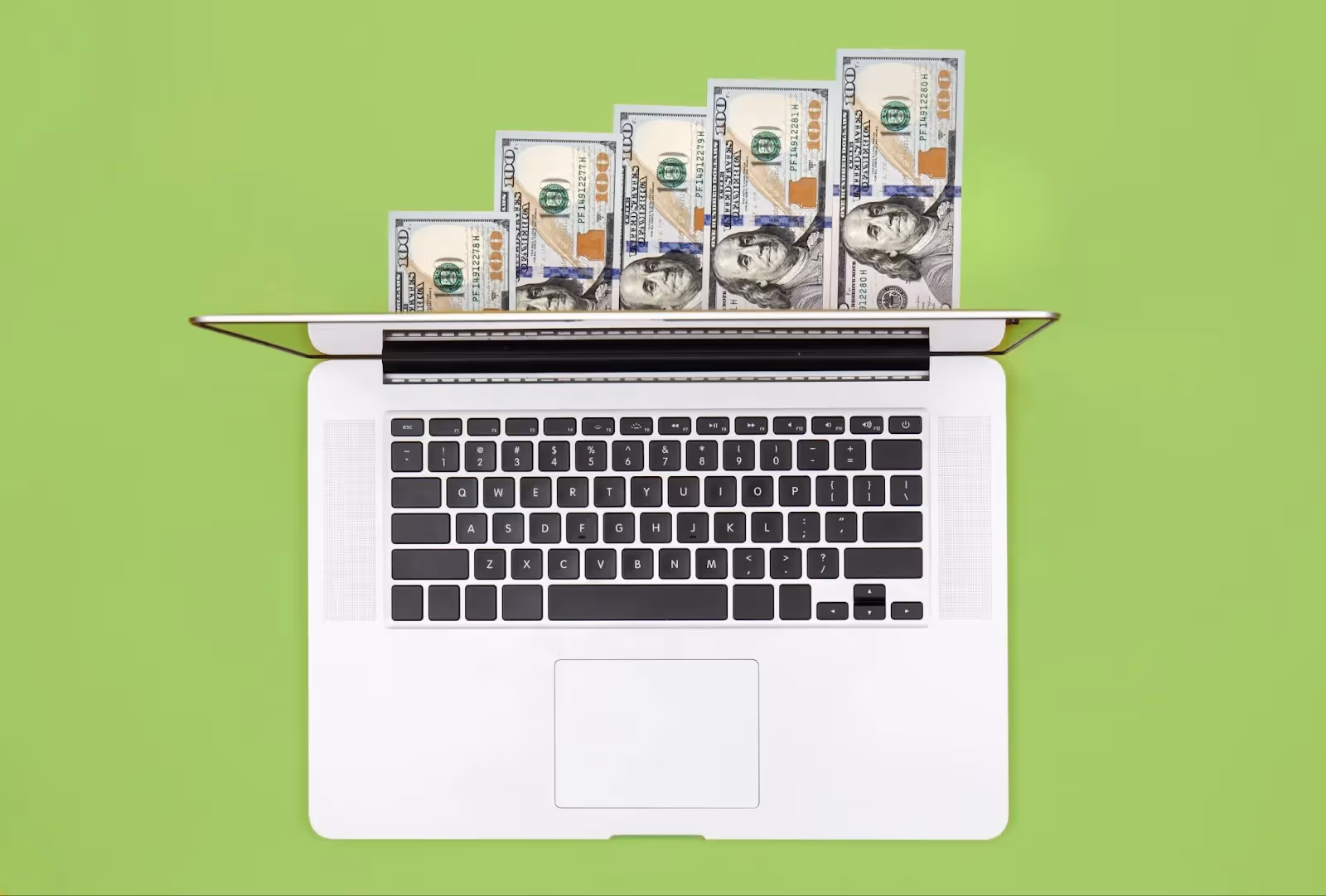 Laptop displaying increasing stacks of $100 bills representing affiliate marketing income growth on a bright green background