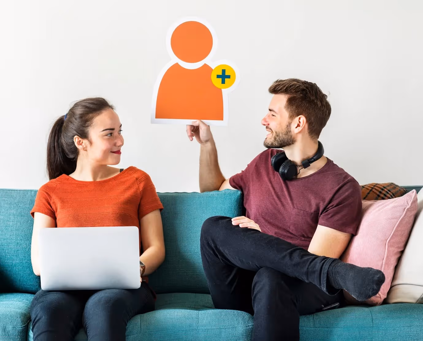 Marketing team collaborating on referral program strategy with a woman using laptop and man holding user acquisition icon