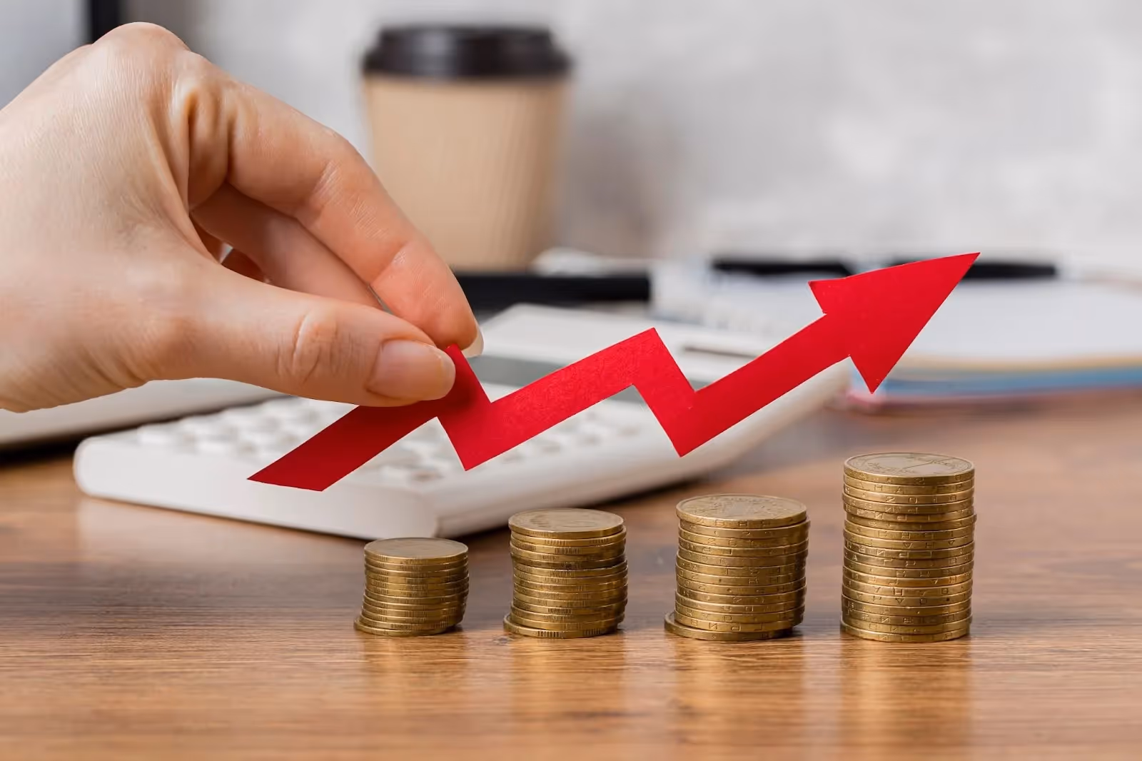 Stacked coins with a rising red arrow symbolizing increasing ROI from customer loyalty programs