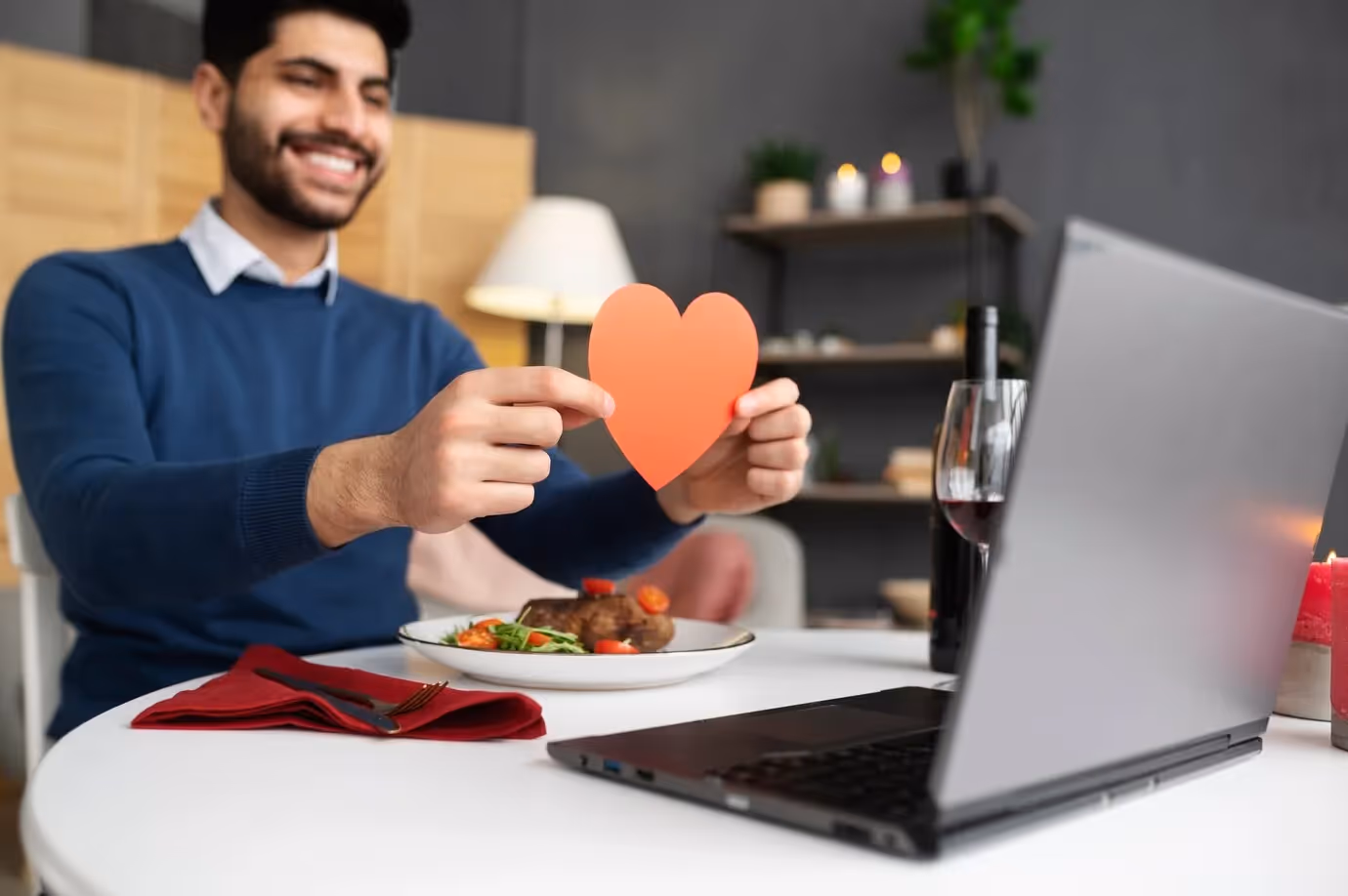 Smiling customer holding a heart shape during a video call, symbolizing a positive brand experience after resolving a complaint.