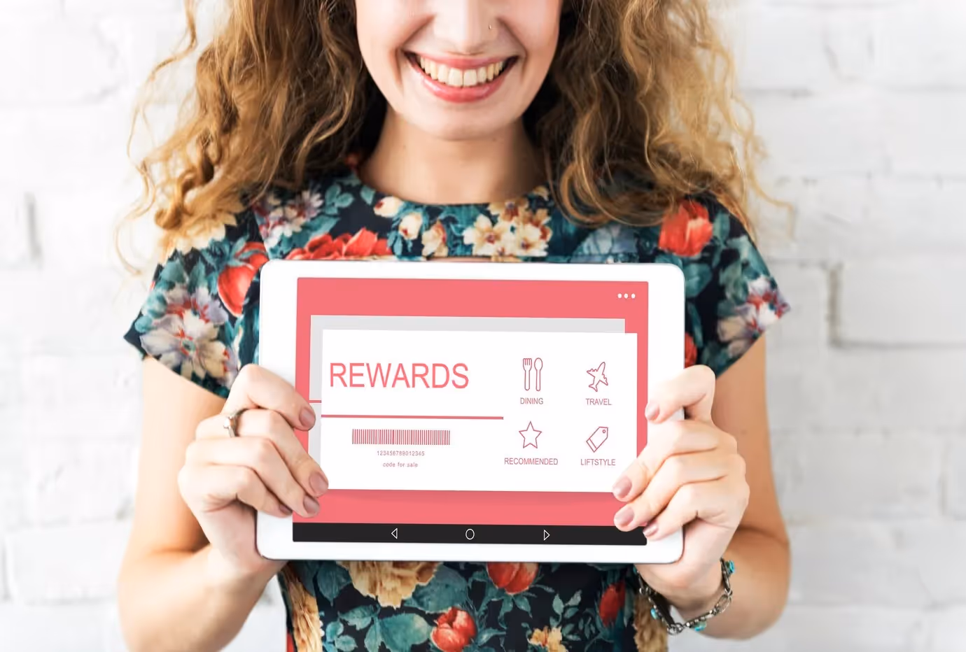 Smiling woman holding a tablet displaying a digital rewards program for dining, travel, and lifestyle benefits