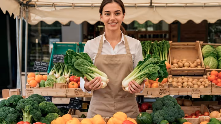 A small business owner at a farmer’s market showcasing fresh produce, representing personalized customer loyalty strategies for 2025