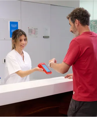 Persona pagando con un reloj inteligente en un datáfoto Getnet 