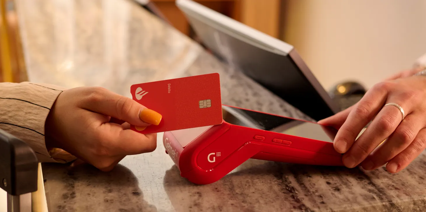 Persona pagando con una tarjeta de crédito en un datáfoto Getnet 