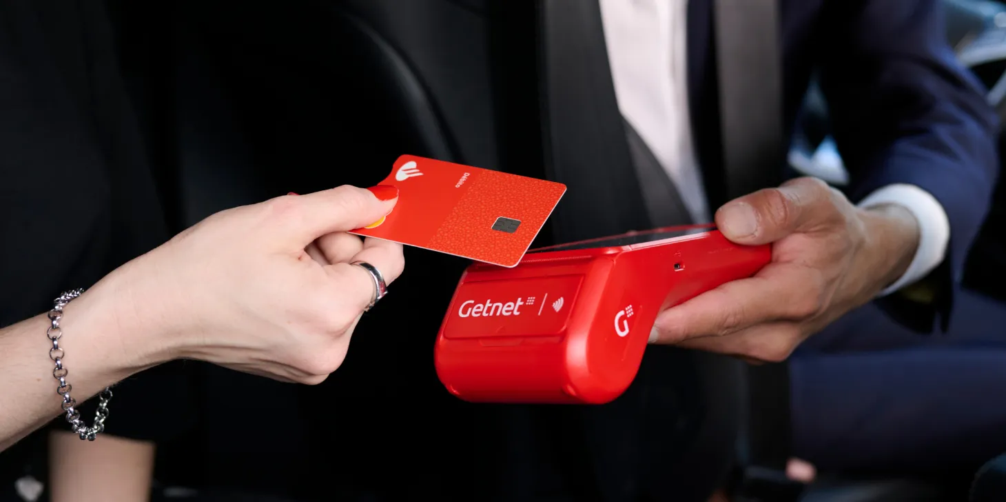 Persona pagando con una tarjeta de crédito en un datáfoto Getnet 