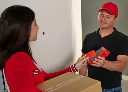 Persona pagando con una tarjeta de crédito en un datáfoto Getnet en su propio domicilio