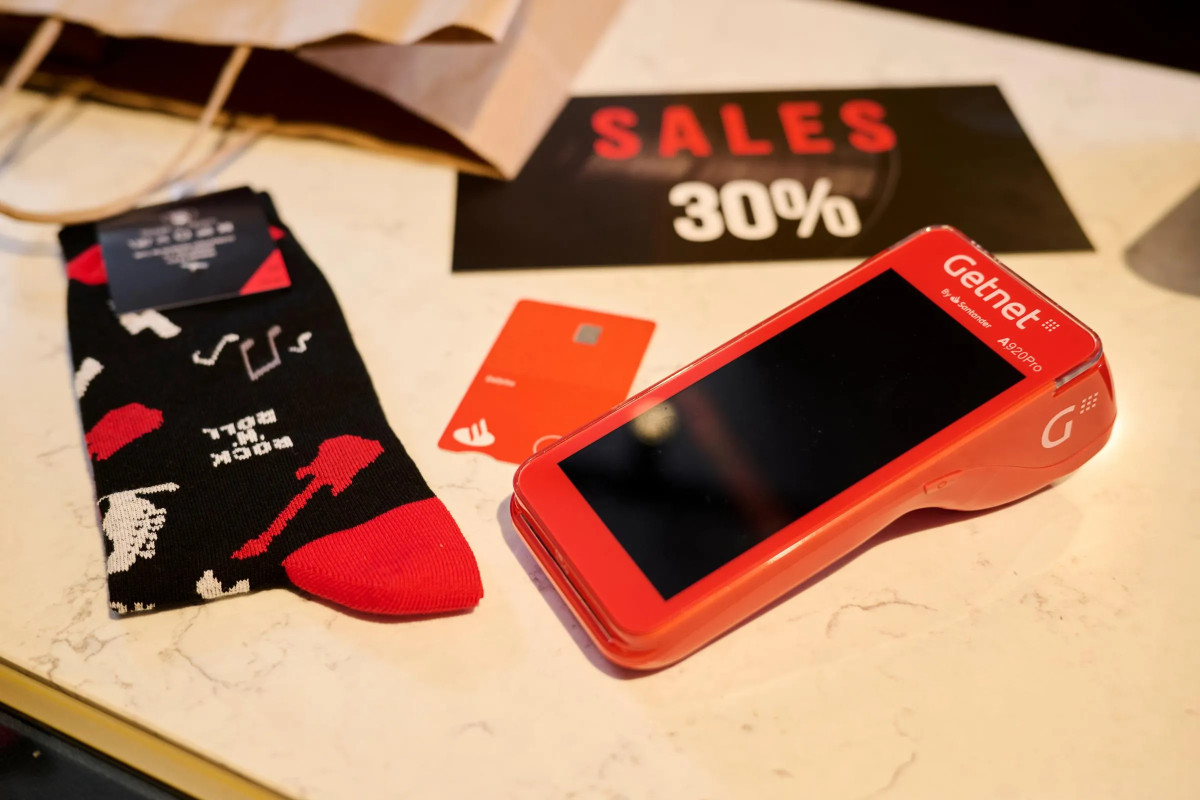 mostrador de tienda de ropa con un tpv y una tarjeta de crédito