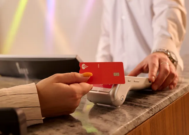 Persona pagando con una tarjeta de crédito en un datáfoto Getnet 