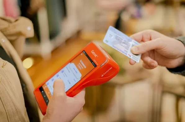 Persona pagando con una tarjeta de crédito en un datáfoto Getnet 