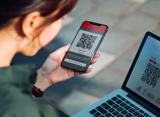 Persona pagando con un smarphone desde un QR