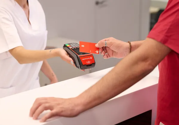 Persona pagando con una tarjeta de crédito en un datáfoto Getnet 