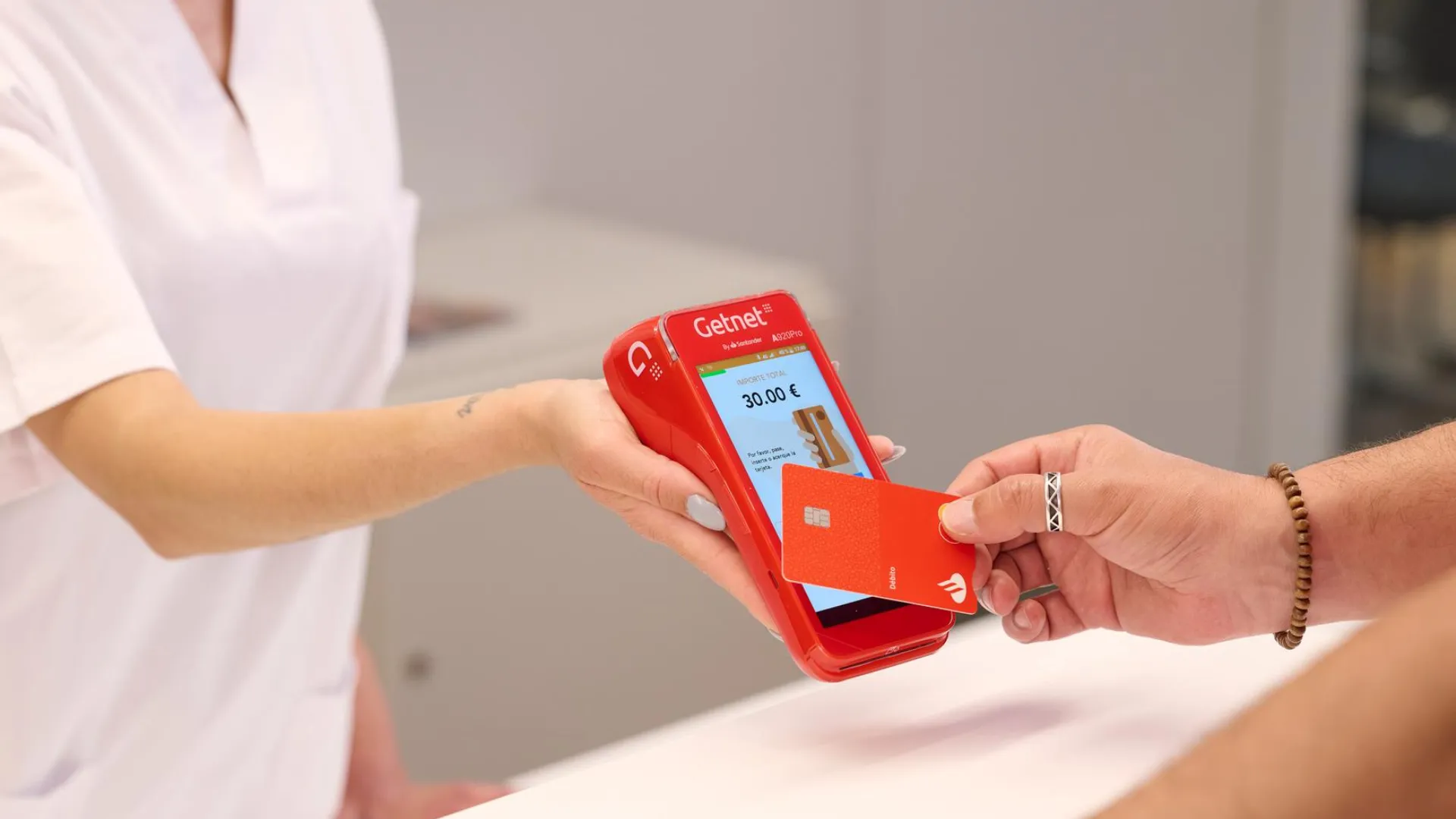 Persona pagando con una tarjeta de crédito en un datáfoto Getnet 