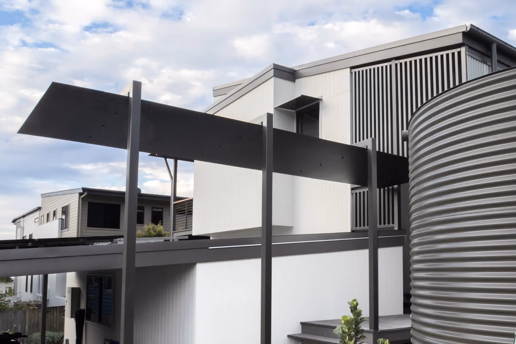Exterior of a modern white home with a dark metal canopy